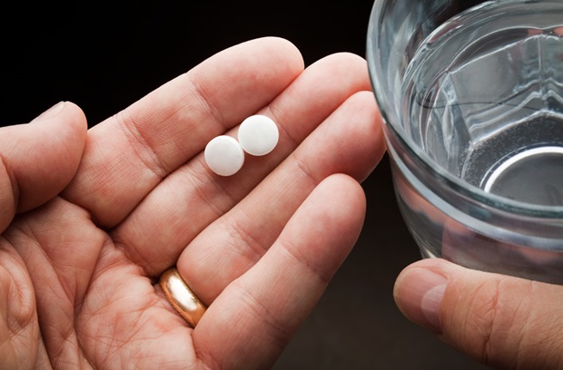Hand holding 2 pills