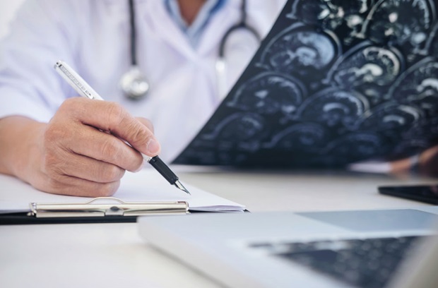 Doctor reading x-ray and writing notes