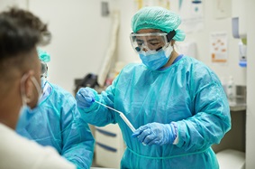 Nurse in PPE performing COVID test