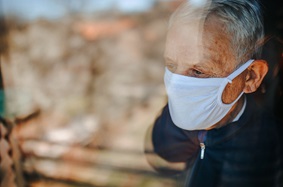 Masked man at window during COVID pandemic