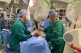 Dr. Levin and Dr. Steinberger working in an operating room