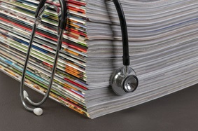 stethoscope draped over magazines