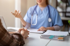 A physician and patient are shown engaged in a counseling session.