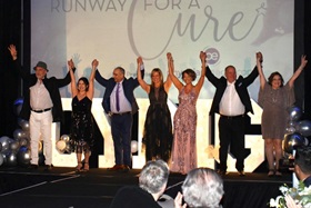 people holding their arms up raised in joy