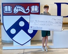 Ayden holding donation check