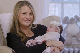 Penn Fertility Care patient Deirdre holding her baby girl Kelce and smiling