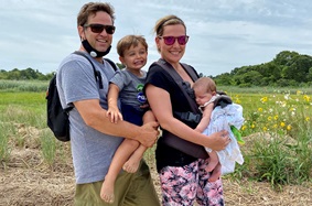 Kimm Dinsmore and family smiling on the beach