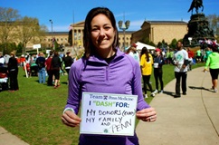 Laurie holding sign saying she Dashes for her donor, family, and Penn.