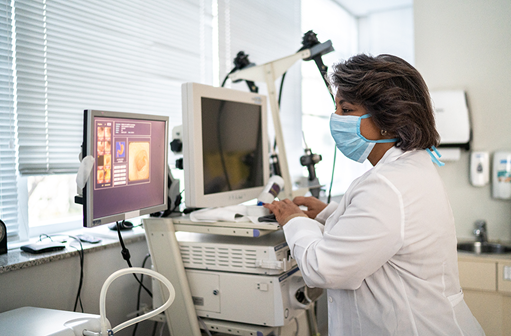 Medical professional looking at gastroenterology results on computer screen