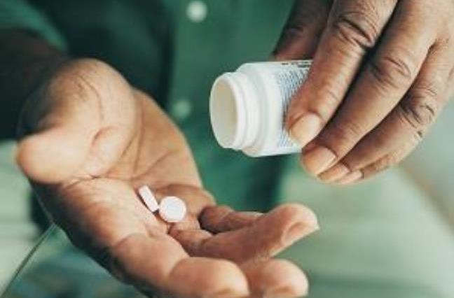 man holding pill bottle