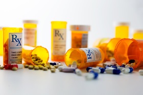 Prescription bottles and pills on a counter.
