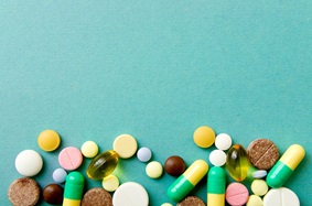 shot of pills in various colors on a blue background