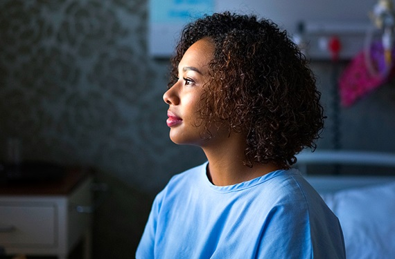 Young female patient sitting on hospital bed