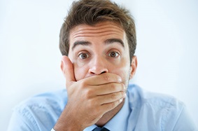 middle_aged_man_wearing_blue_collared_shirt_covers_mouth