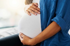 Pregnant person holding their stomach