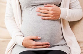 Pregnant person holding their belly