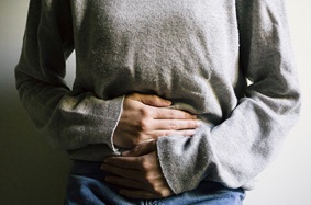 woman holding lower abdomen in pain