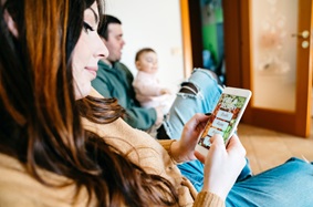 Woman using a smartphone to order dinner for her family.