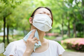 A woman sweats while wearing a mask.