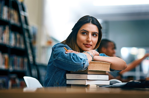 Young female college student doing school work in the library