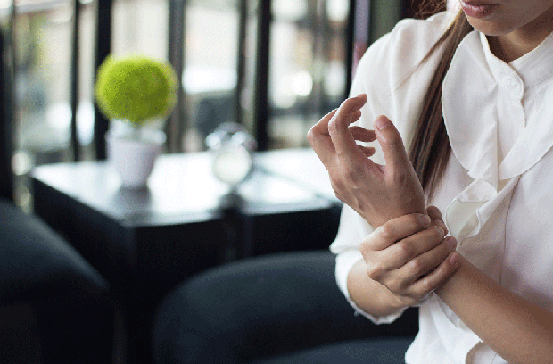 young woman holding her wrist in pain