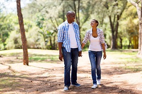 a man and woman walking outside while holding hands