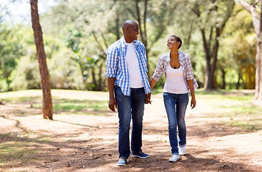 a man and woman walking outside while holding hands