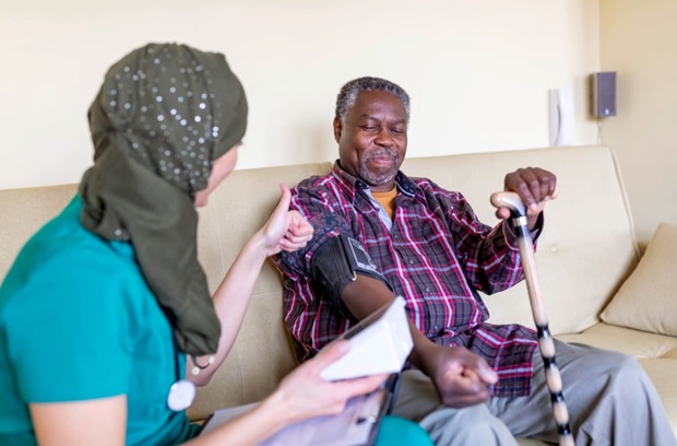 Female Doctor Checking Blood Pressure of Senior Patient