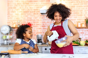 Mother and young daughter baking holiday cookies