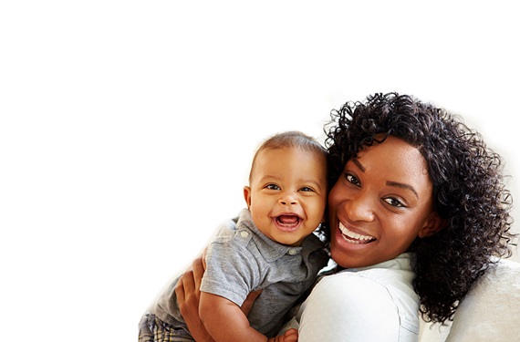 A mom smiling while holding her baby