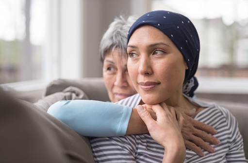 Young woman with cancer receives a comforting hug from her mother