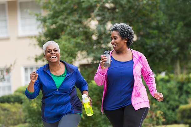 Two Senior Women Walking Outside With Water Bottles
