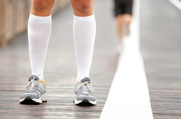 Older man wearing sneakers and compression socks