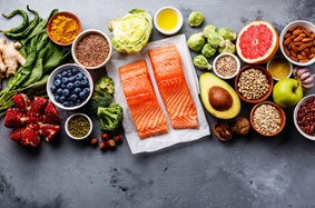 Fish, nuts, beans, fruits and vegetables on slate