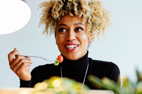 Woman thinking while eating a salad