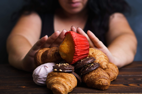 zoomed_in_on_women_showing_half_face_body_pushing_away_sweets_pastries_baked_goods