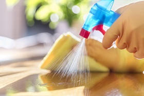 Close-up of a person spray cleaning solution