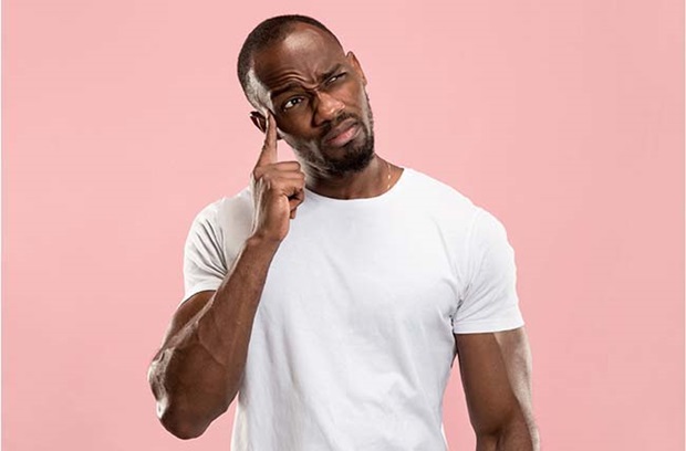 middle_aged_man_points_finger_to_head_deep_thought_confused_deja_vu_pink_background