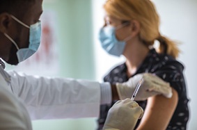 doctor giving woman flu shot