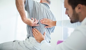 doctor looking at patient's back