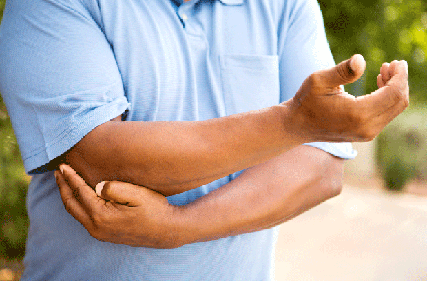 Man holding elbow in pain 