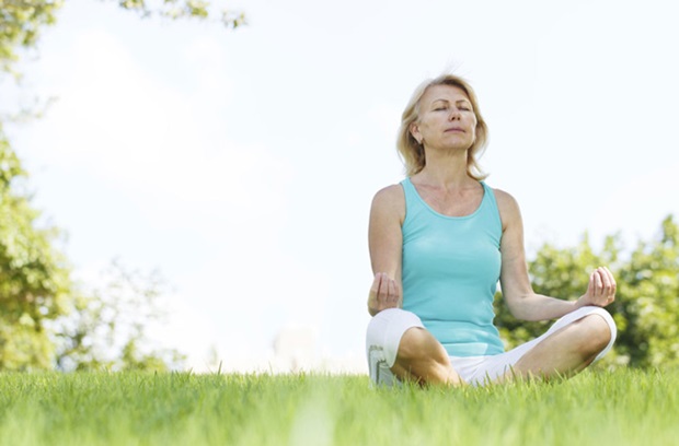 woman meditating in grass