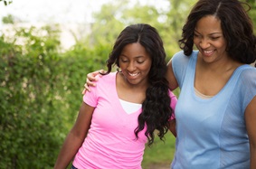 a mother and daughter walking arm in arm