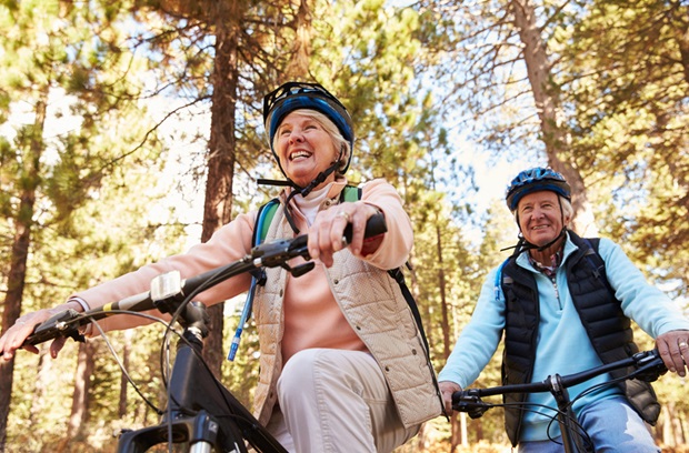 an older man and woman biking together in the Fall