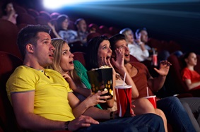 people looking scared while sitting in a movie theatre