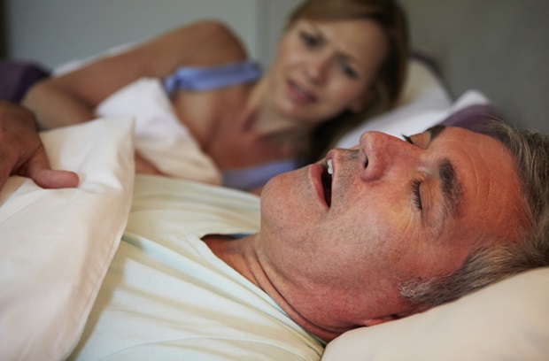 woman looking at her husband who is snoring