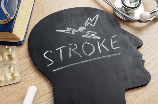 black_chalkboard_shape_of_head_with_stroke_written_on_it_medicine_book_chalk_stethoscope_in_wooden_background