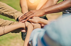 Hands of various people supporting each other in a circle