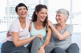 three women sitting next to each other, smiling