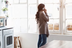 Woman on phone looking out window